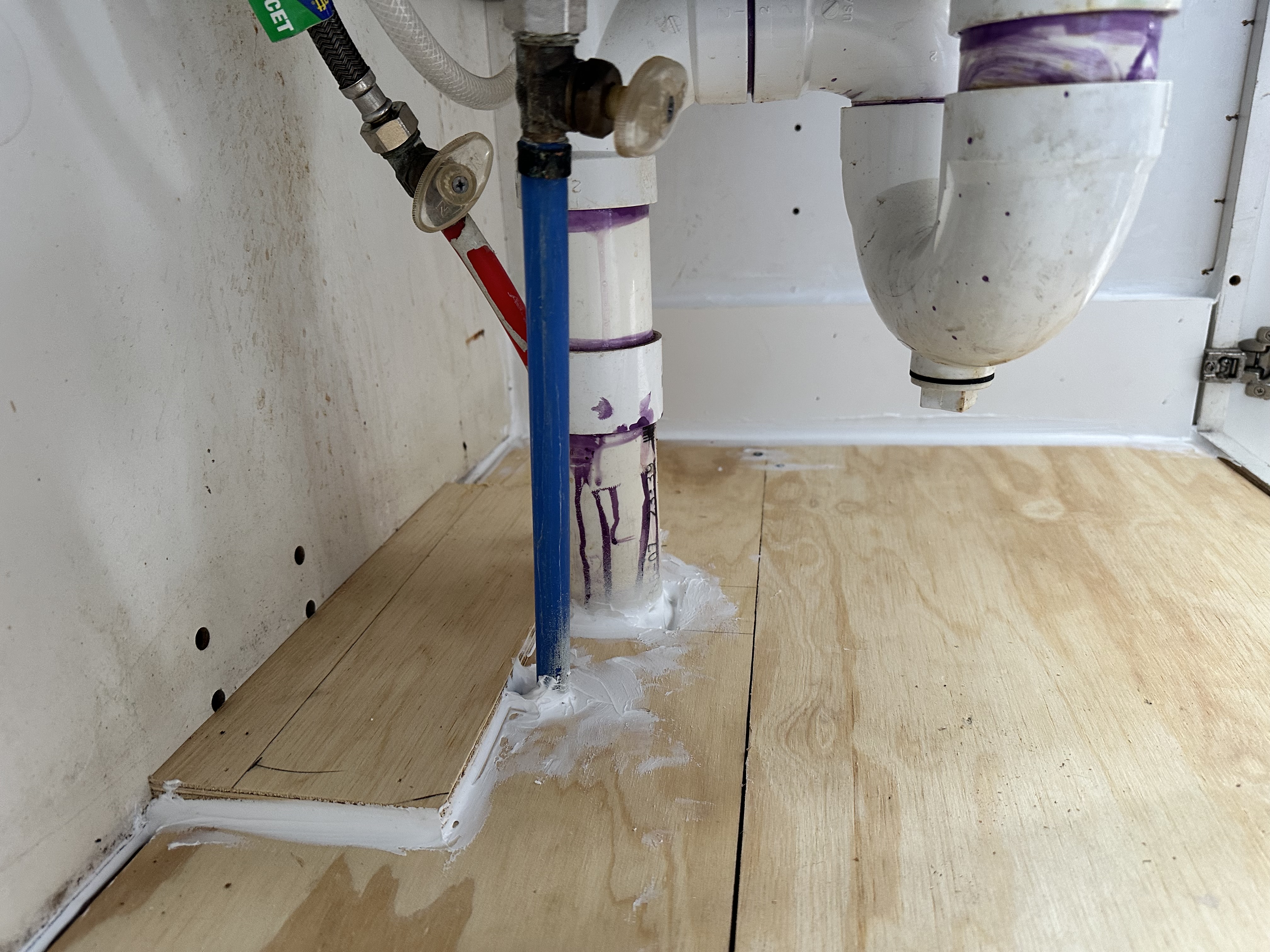 Sealed plumbing openings through the new plywood cabinet base