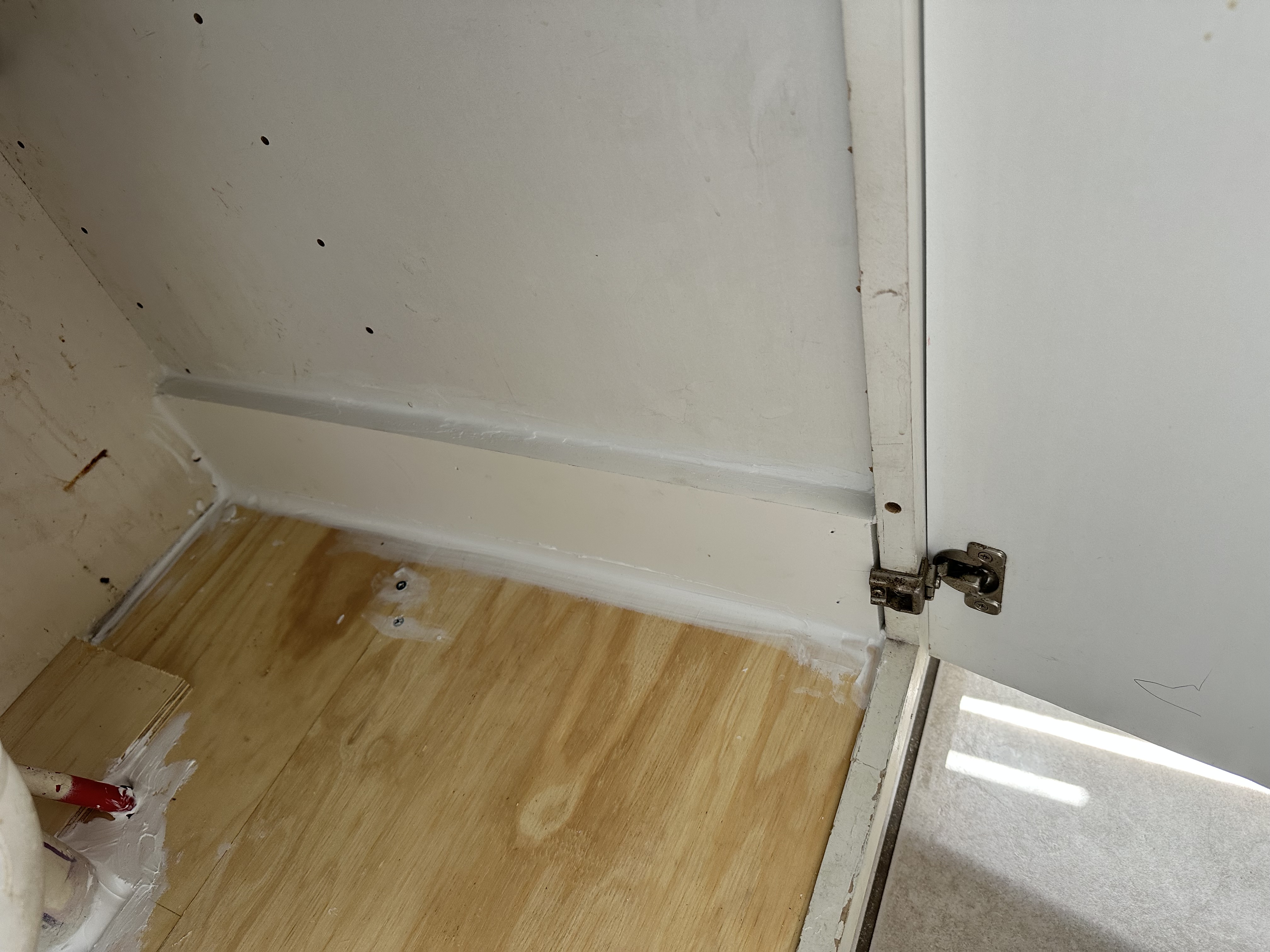 Repaired cabinet side and plywood base with sealed edges
